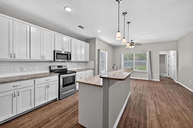 515 W Broad St, Pilot Point, TX 76258 - kitchen featuring appliances with stainless steel finishes, dark wood-type flooring, tasteful backsplash, a ceiling fan, and recessed lighting