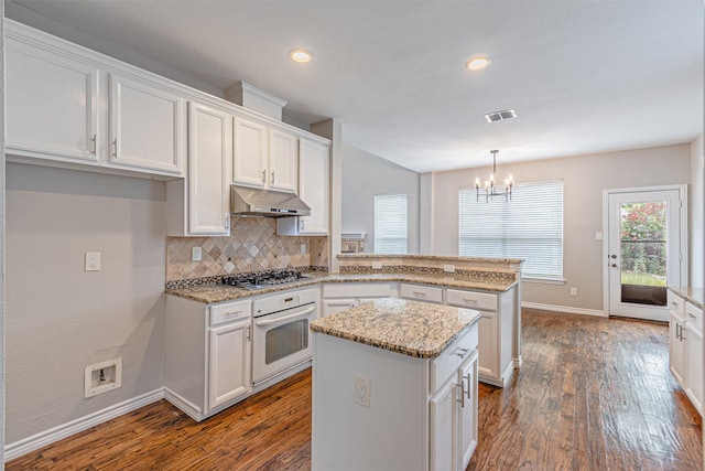 1900 Sumac Dr, Flower Mound, TX 75028 - kitchen featuring oven, under cabinet range hood, a peninsula, stainless steel gas stovetop, and a chandelier