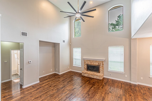 1900 Sumac Dr, Flower Mound, TX 75028 - unfurnished living room with a towering ceiling, a ceiling fan, healthy amount of natural light, wood finished floors, and a brick fireplace