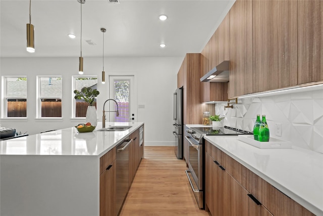 404 Cleaves St, Dallas, TX 75203 - kitchen with stainless steel appliances, modern cabinets, under cabinet range hood, light countertops, and light wood-style floors