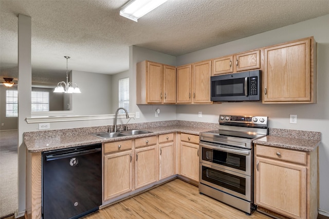 1640 Fieldstone Dr, Little Elm, TX 75068 - kitchen with appliances with stainless steel finishes, light brown cabinetry, healthy amount of natural light, a textured ceiling, and light wood-style flooring