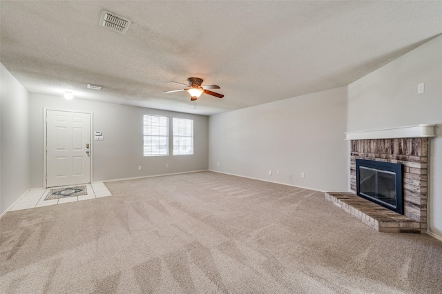 1640 Fieldstone Dr, Little Elm, TX 75068 - unfurnished living room with ceiling fan, light colored carpet, a brick fireplace, and a textured ceiling