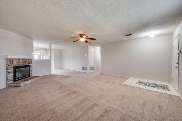 1640 Fieldstone Dr, Little Elm, TX 75068 - unfurnished living room featuring a ceiling fan, carpet floors, a fireplace, and a textured ceiling