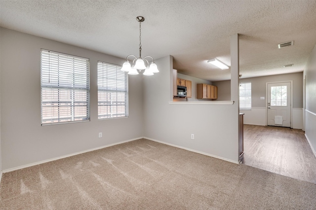 1640 Fieldstone Dr, Little Elm, TX 75068 - carpeted empty room featuring a textured ceiling and a chandelier