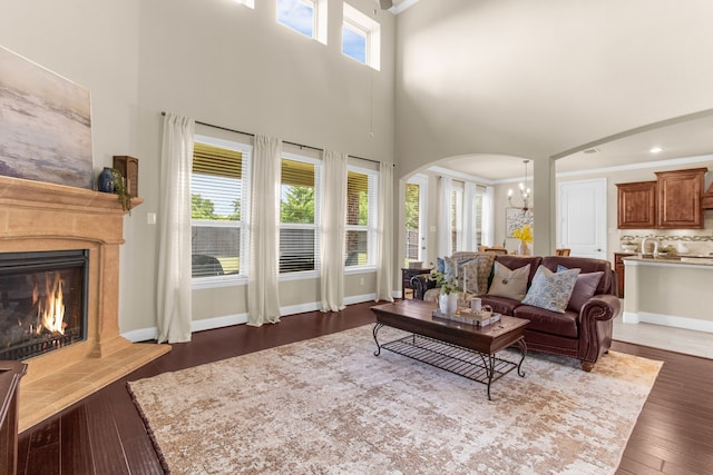 10014 Edgeway Cir, Rowlett, TX 75089 - living area featuring arched walkways, a high ceiling, a glass covered fireplace, and dark wood-style floors
