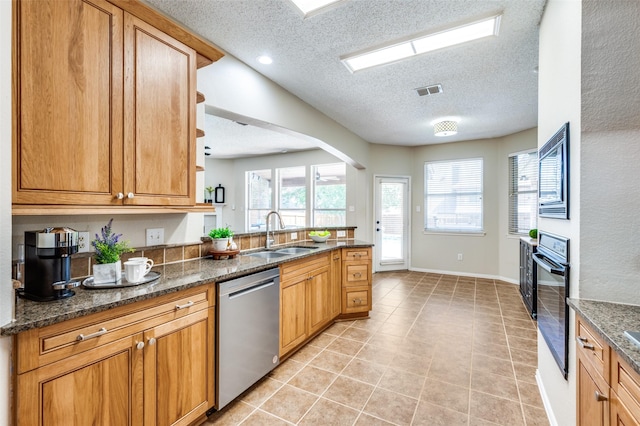2701 Timberhill Dr, Flower Mound, TX 75028 - kitchen featuring dishwasher, a textured ceiling, black oven, light tile patterned floors, and dark stone counters