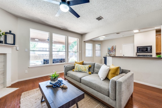2701 Timberhill Dr, Flower Mound, TX 75028 - living area with plenty of natural light, a ceiling fan, wood finished floors, arched walkways, and a textured ceiling