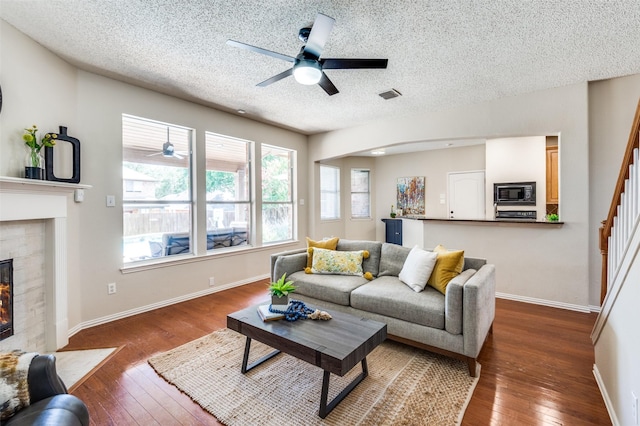 2701 Timberhill Dr, Flower Mound, TX 75028 - living room featuring ceiling fan, a textured ceiling, hardwood / wood-style floors, and a fireplace