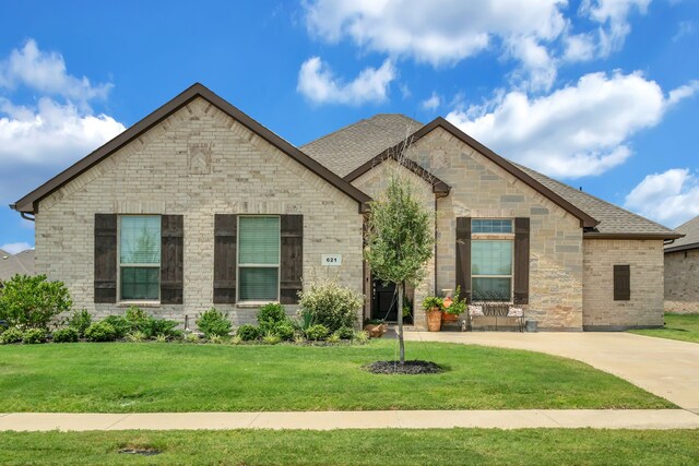 621 Mesquite Grove Rd, Midlothian, TX 76065 - french country inspired facade featuring a front lawn, roof with shingles, and stone siding