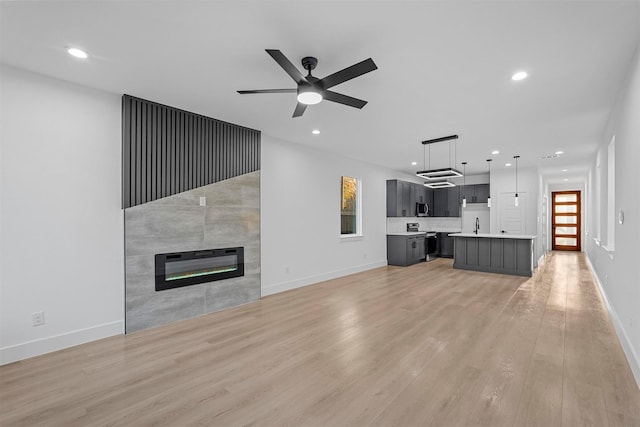 6112 Carlton Garret St, Dallas, TX 75215 - unfurnished living room featuring recessed lighting, light wood-style flooring, a ceiling fan, and a tiled fireplace