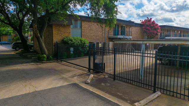 10212 Regal Oaks Dr Unit C, Dallas, TX 75230 - view of front of house featuring brick siding, a fenced front yard, and a balcony