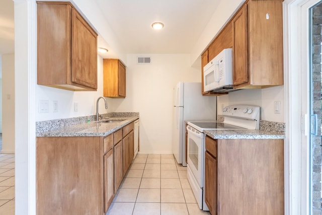 10212 Regal Oaks Dr Unit C, Dallas, TX 75230 - kitchen with white appliances, light tile patterned flooring, brown cabinetry, and light stone countertops