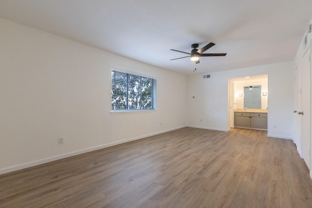 10212 Regal Oaks Dr Unit C, Dallas, TX 75230 - unfurnished bedroom featuring light wood-style floors, connected bathroom, and a ceiling fan