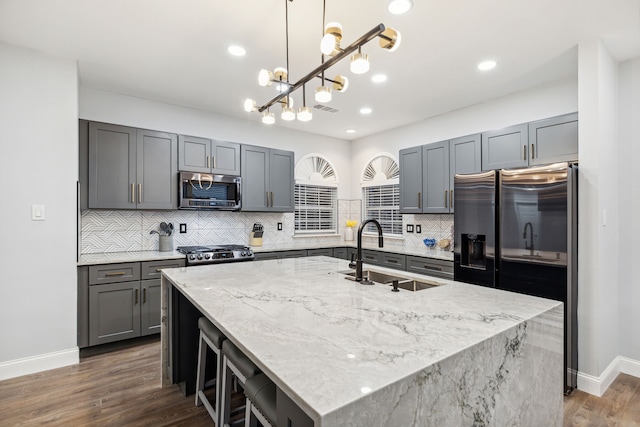 4017 Black Oak Dr, Carrollton, TX 75007 - kitchen with stainless steel appliances, light stone counters, backsplash, an island with sink, and recessed lighting