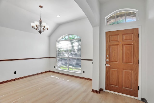 1629 Lakeside Dr, Allen, TX 75002 - foyer featuring wood finished floors, arched walkways, a chandelier, and lofted ceiling