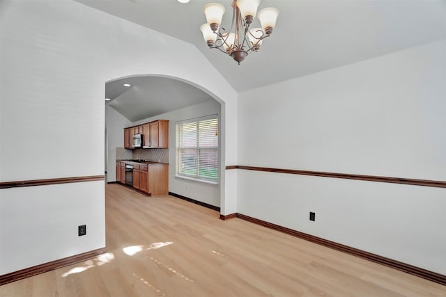 1629 Lakeside Dr, Allen, TX 75002 - unfurnished dining area featuring light wood finished floors, lofted ceiling, arched walkways, and a chandelier