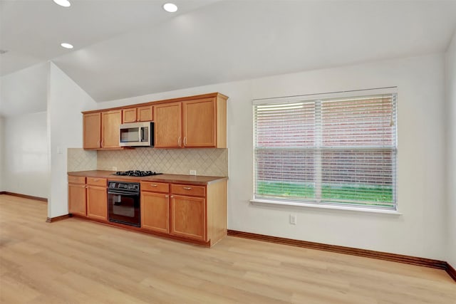 1629 Lakeside Dr, Allen, TX 75002 - kitchen featuring black appliances, light wood-type flooring, backsplash, vaulted ceiling, and recessed lighting