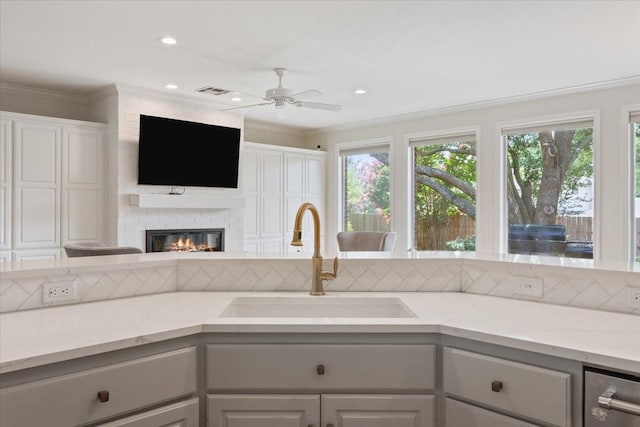 10003 Willow Bend Dr, Woodway, TX 76712 - kitchen featuring light countertops, a ceiling fan, crown molding, open floor plan, and a large fireplace