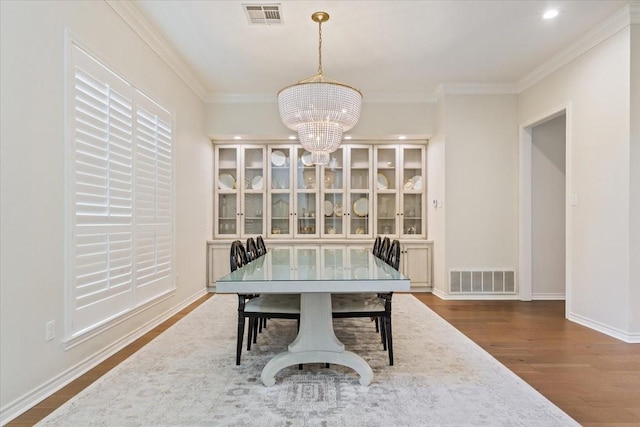 10003 Willow Bend Dr, Woodway, TX 76712 - dining area with wood finished floors, a chandelier, crown molding, and recessed lighting