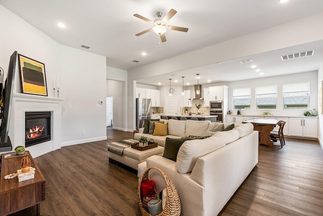 313 Savannah Ln, Oak Point, TX 75068 - living room featuring a ceiling fan, dark wood-type flooring, recessed lighting, and a glass covered fireplace