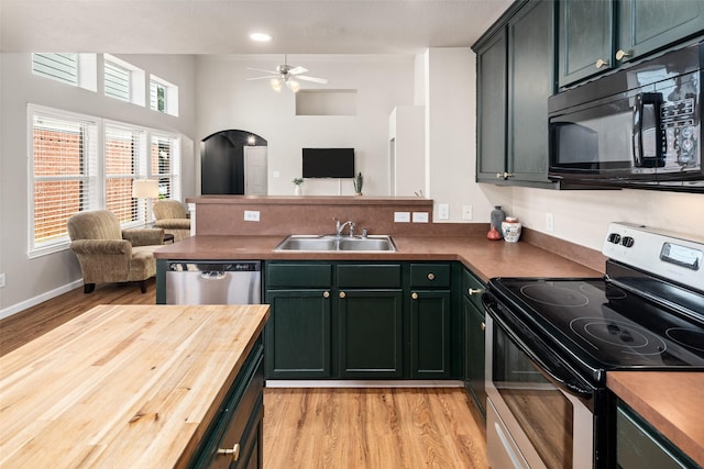 9028 Wild Rose Ln, Cross Roads, TX 76227 - kitchen featuring stainless steel appliances, open floor plan, a peninsula, light wood finished floors, and recessed lighting