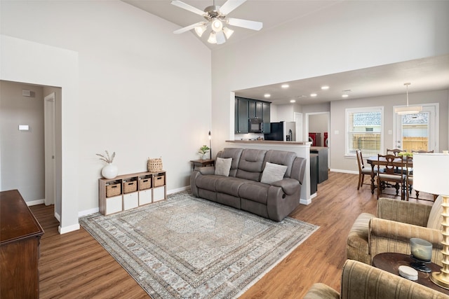 9028 Wild Rose Ln, Cross Roads, TX 76227 - living room featuring light wood-type flooring, ceiling fan, high vaulted ceiling, and recessed lighting