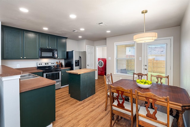 9028 Wild Rose Ln, Cross Roads, TX 76227 - kitchen featuring appliances with stainless steel finishes, washer / dryer, wood counters, a kitchen island, and light wood-style floors