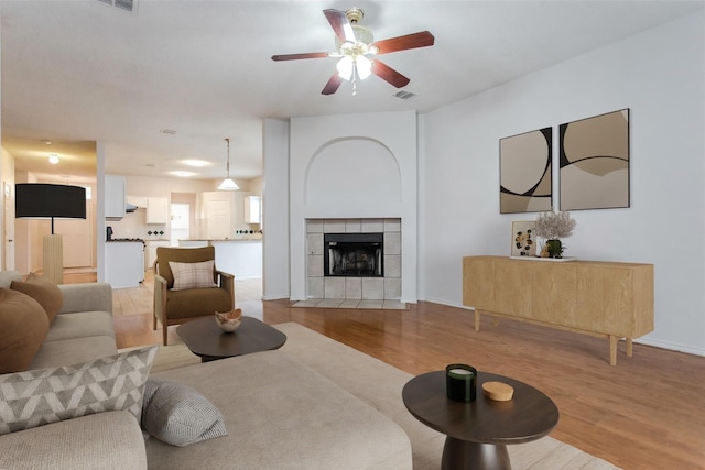 738 Opal Ln, Mesquite, TX 75149 - living room with light wood finished floors, ceiling fan, and a tile fireplace