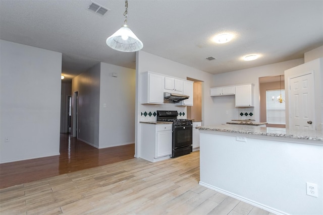 738 Opal Ln, Mesquite, TX 75149 - kitchen with black range with gas cooktop, under cabinet range hood, white cabinetry, and light wood-style flooring