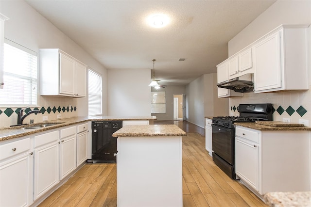 738 Opal Ln, Mesquite, TX 75149 - kitchen with black appliances, under cabinet range hood, a kitchen island, a peninsula, and white cabinets