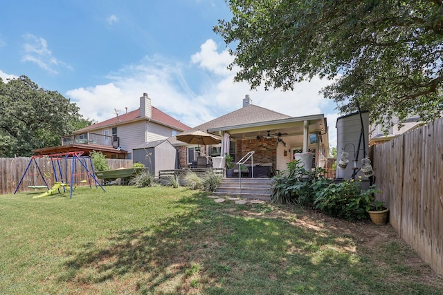 504 Lake Point Dr, Little Elm, TX 75068 - rear view of house with a playground, a storage shed, a fenced backyard, a ceiling fan, and a wooden deck
