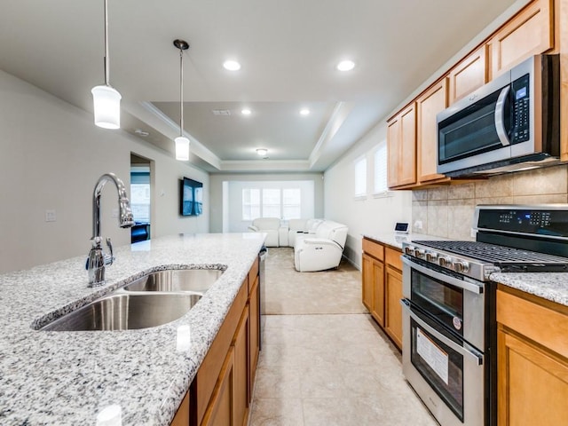 1244 Eagle Ln, Little Elm, TX 76227 - kitchen with stainless steel appliances, a raised ceiling, open floor plan, light stone countertops, and hanging light fixtures
