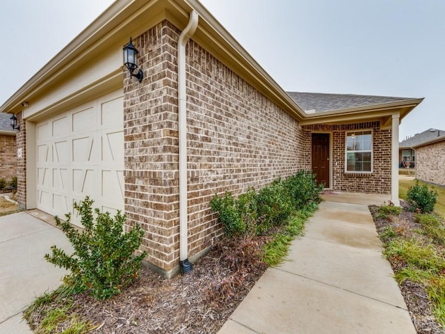 1244 Eagle Ln, Little Elm, TX 76227 - entrance to property with brick siding, a garage, roof with shingles, and driveway