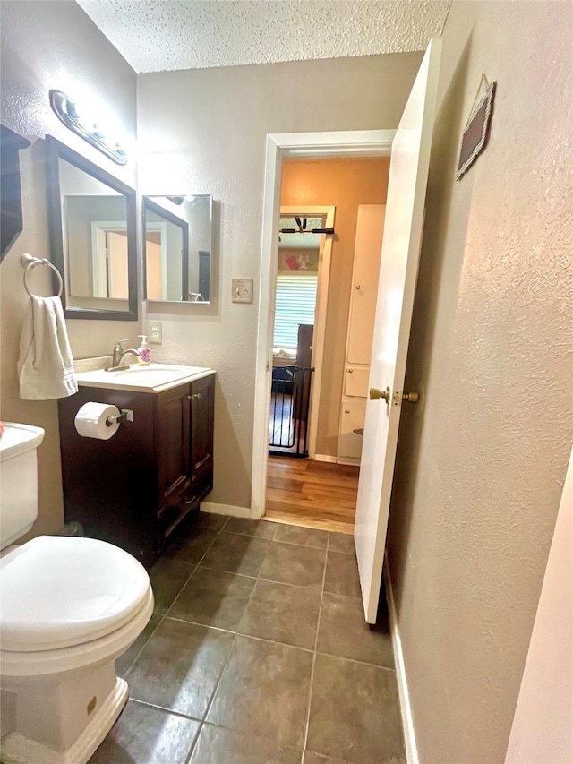 309 Bellaire Dr, Denton, TX 76209 - bathroom with tile patterned flooring, vanity, a textured ceiling, and a textured wall
