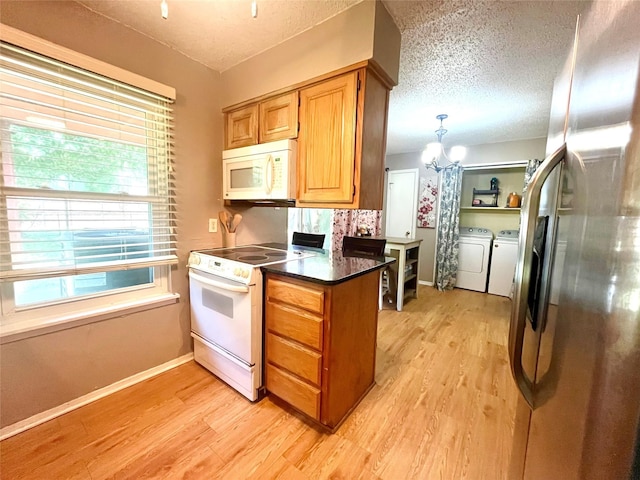 309 Bellaire Dr, Denton, TX 76209 - kitchen featuring white appliances, washer and clothes dryer, light wood-type flooring, healthy amount of natural light, and a textured ceiling