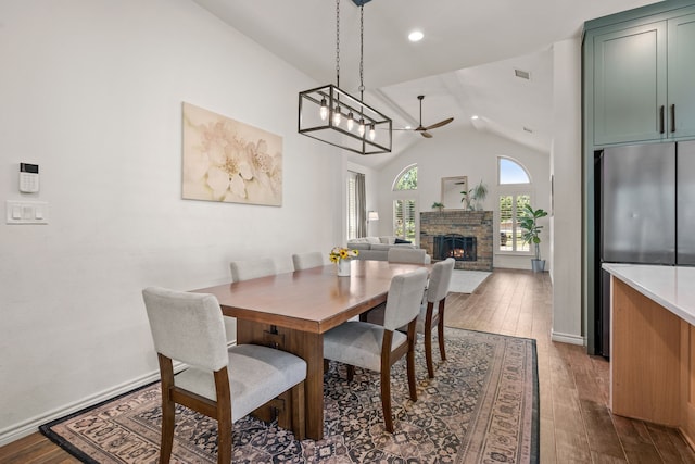 1402 Summer Dell Ct, Keller, TX 76262 - dining space featuring a warm lit fireplace, a ceiling fan, dark wood-style flooring, vaulted ceiling, and recessed lighting