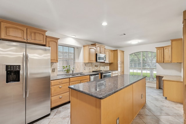 2521 Misty Glen Dr, Flower Mound, TX 75028 - kitchen with appliances with stainless steel finishes, a kitchen island, tasteful backsplash, dark stone countertops, and recessed lighting