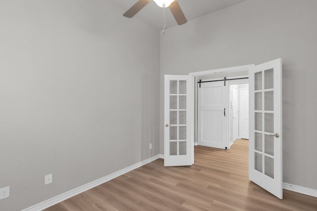 813 Louisville Rd, Savannah, TX 76227 - unfurnished bedroom with french doors, light wood-style floors, a barn door, and a ceiling fan