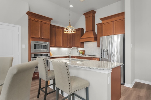 813 Louisville Rd, Savannah, TX 76227 - kitchen featuring stainless steel appliances, premium range hood, light wood-style flooring, decorative backsplash, and light stone countertops