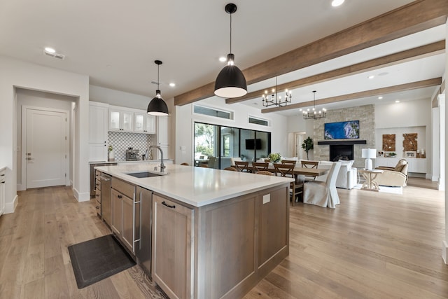 1454 Sunset Point Dr, Flower Mound, TX 75022 - kitchen with light countertops, open floor plan, an island with sink, backsplash, and a fireplace