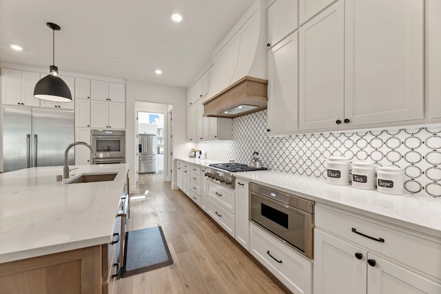 1454 Sunset Point Dr, Flower Mound, TX 75022 - kitchen with appliances with stainless steel finishes, light wood-style flooring, decorative backsplash, white cabinets, and light stone countertops