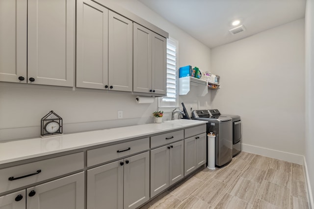 1454 Sunset Point Dr, Flower Mound, TX 75022 - laundry area with washer and dryer, cabinet space, and light wood-style floors