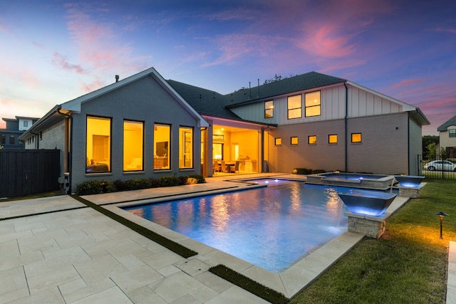 1454 Sunset Point Dr, Flower Mound, TX 75022 - back of property with a patio area, board and batten siding, and a pool with connected hot tub