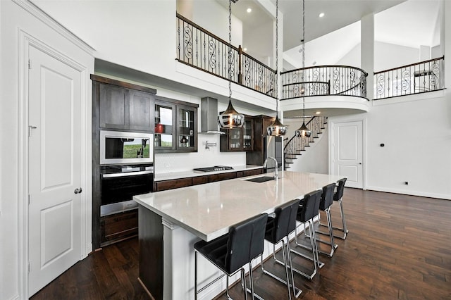 1018 Cascading Creek Dr, Rockwall, TX 75087 - kitchen with appliances with stainless steel finishes, wall chimney range hood, dark wood-style flooring, a large island, and glass insert cabinets
