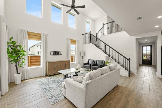 2100 Jade Forest Ln, Mesquite, TX 75181 - living room with light wood finished floors, ceiling fan, a high ceiling, stairs, and recessed lighting