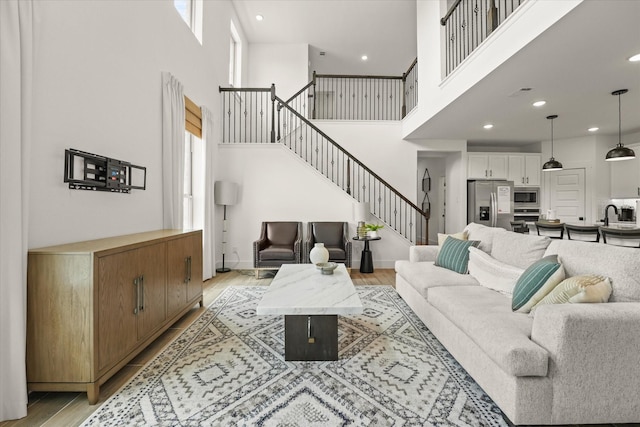 2100 Jade Forest Ln, Mesquite, TX 75181 - living room featuring stairway, a high ceiling, light wood-style flooring, and recessed lighting