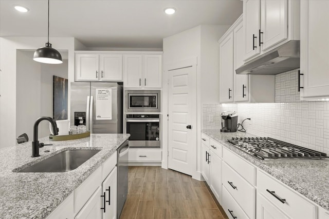 2100 Jade Forest Ln, Mesquite, TX 75181 - kitchen with stainless steel appliances, under cabinet range hood, white cabinets, recessed lighting, and decorative light fixtures