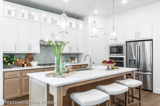 3613 Barrel Ln, Aubrey, TX 76227 - kitchen featuring stainless steel appliances, decorative backsplash, a kitchen breakfast bar, light countertops, and decorative light fixtures