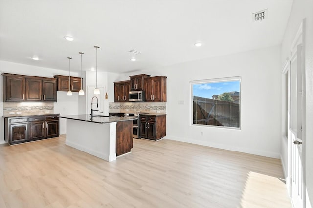 3901 Tule Ranch Rd, Fort Worth, TX 76262 - kitchen featuring appliances with stainless steel finishes, decorative backsplash, light wood-type flooring, dark brown cabinetry, and recessed lighting