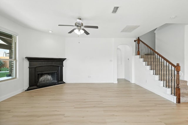 3901 Tule Ranch Rd, Fort Worth, TX 76262 - unfurnished living room featuring light wood-style floors, ceiling fan, stairs, and arched walkways